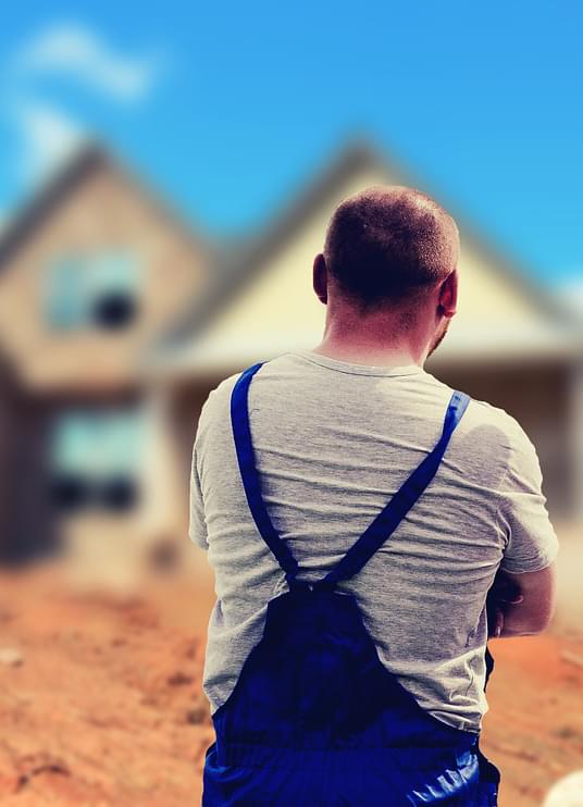 Construction worker looking at building a house